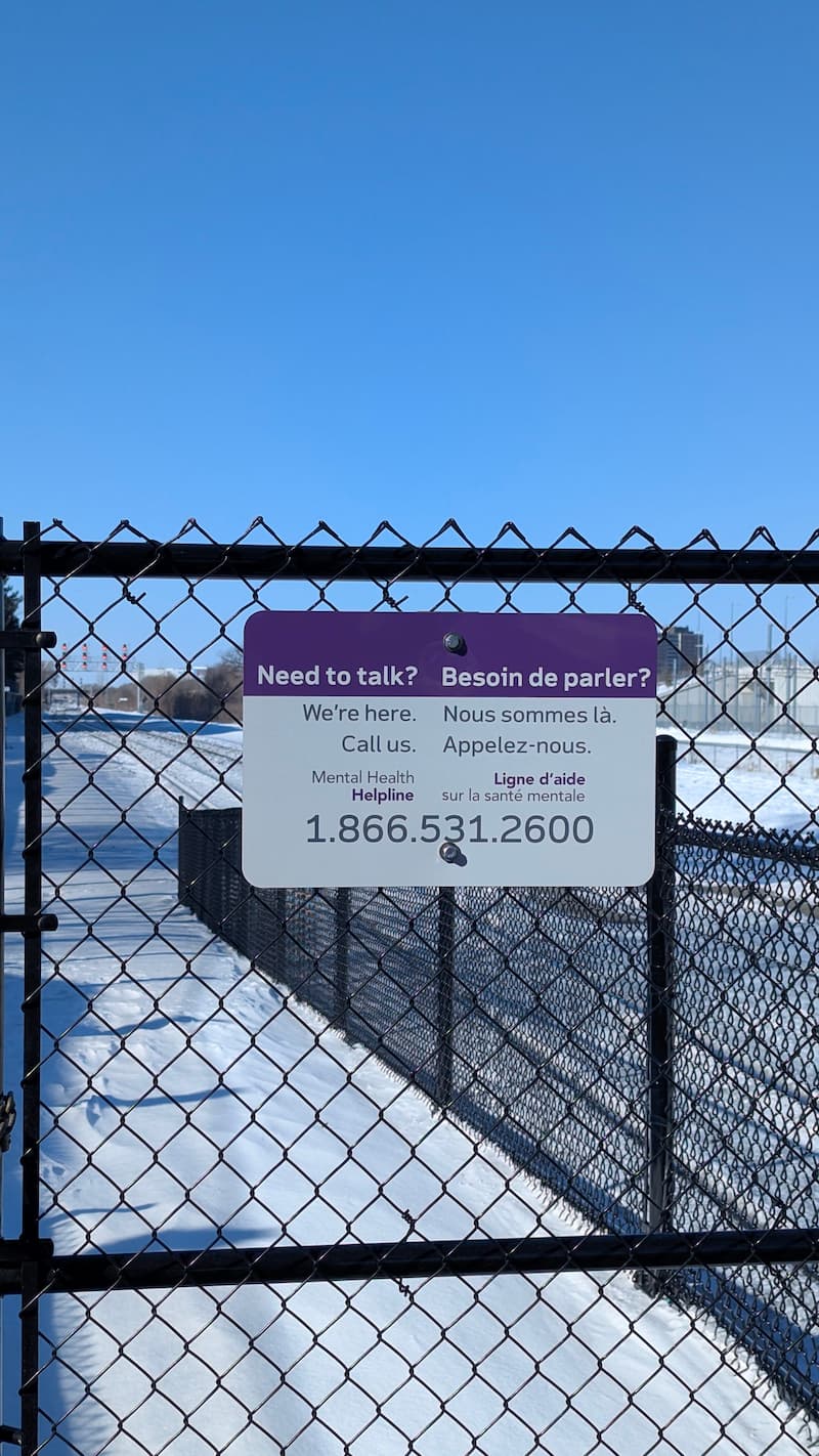 Mental health support contact sign at a commuter train station